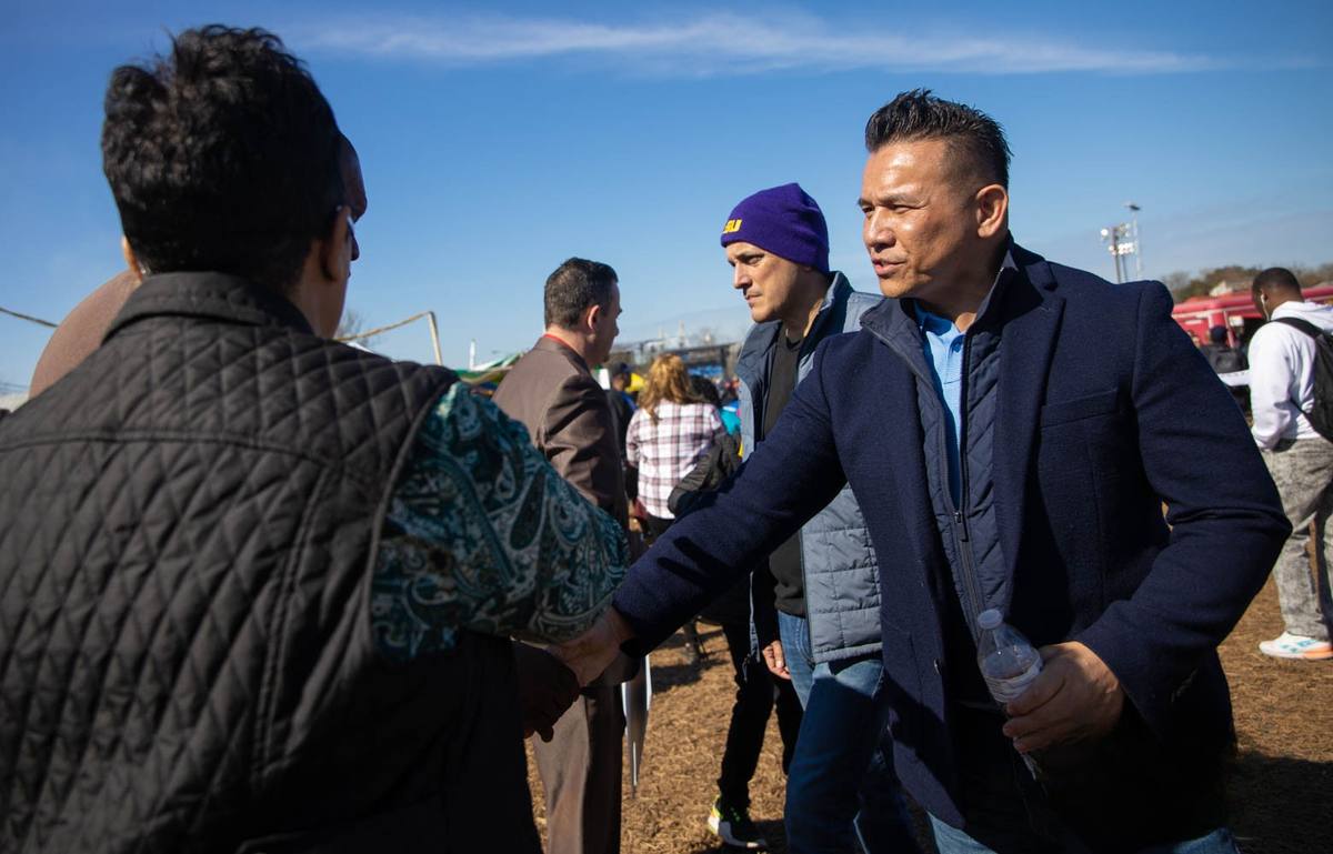 Dr. Willie Ng listening to a community member at a public event